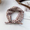 Detalle de un pañuelo de algodón y seda con diseño geométrico atado a un bolso - Triángulo Geométrico Blanco