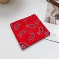 Nahaufnahme des roten Baumwolltuches mit weißem Paisley-Muster und gesäumten Kanten - Paisley Rot