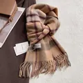 Nahaufnahme brauner Vintage Karoschal aus Wolle mit Fransen und gewebtem Markenlabel - Camel