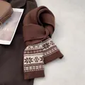 Detailed knit texture of Fair Isle wool scarf with snowflake patterns and earth tones - Coffee