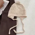 Handmade wool knit trapper hat in beige with ear flaps and decorative floral patterns - Off White