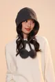 Close-up of dark grey wool knit earflap hat featuring decorative soft plush pom-poms - Gray