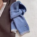 Detail of wool blend knit scarf in blue with white stripes and a golden metal logo - Blue