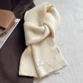 Detail of a creamy white wool blend knit scarf with a stylish cross-pull design - Cream Rice