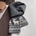 Macro detail of thick knitted winter scarf featuring Nordic elk patterns and leather tag - Jacquard Reindeer Style / Dark Gray