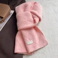Close-up of pink wool blend knit scarf with diamond pattern and woven brand label - Pink