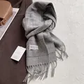 Gros plan sur une écharpe en laine à carreaux gris avec franges et étiquettes de marque - 180x30cm / Carreaux Gris Clair