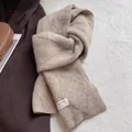 Details des Wollmischschals in Haferfarbe mit Köperstruktur und Markenwebetikett - Milchtee Kamel