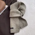 Detail of 100% wool knitted scarf with woven label and premium ribbed texture - Milk Tea Camel