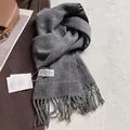 Detail of grey plaid wool scarf with long tassels and Onebagel brand tag on a coat - 180x30cm / Dark Gray Plaid