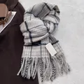 Detailed view of grey and blue plaid wool scarf featuring soft fringe and brand label - Off White