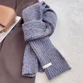 Close-up of chunky mixed wool knit scarf in blue and brown with a white textile label - Blue