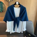 Detail of wool knit shoulder wrap tied over a white long sleeve top on a flower hanger - Navy Blue