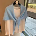 Detail of sky blue knitted mohair shawl with logo label and soft fuzzy texture - Azure Blue
