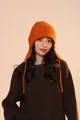 Detail of bright orange knitted earflap hat showing thick wool texture and logo - Ear Protection Style / Orange