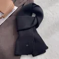 Detail eines schwarzen Strickschals aus Wolle mit Streifen und Metallschließe - Schwarz