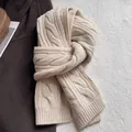 Vue détaillée d'une écharpe en laine à torsades beige avec étiquette WOOL sur le tissu - Blanc Cassé