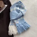 Detail of blue and white checkered knit scarf with fringe and woven studio label - Creamy Blue