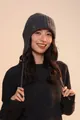 Detail of dark grey knit earflap hat showing thick wool texture and small metal logo - Ear Protection Style / Gray