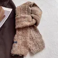 Dettaglio della texture della sciarpa in misto lana bouclé marrone con etichetta - Caramello