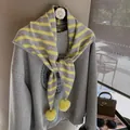 Detail of grey striped knit scarf with bright yellow pom-poms and retro graphic sweatshirt - Yellow