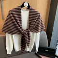 Detailed view of striped wool shawl draped over a white knit sweater with chic neck knot - Reddish Brown