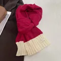 Detail of chunky cable-knit winter scarf in magenta with ivory ribbed trim and woven label - Red and Off-white