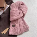Detail shot of pink wool blend scarf with cable knit texture and branded woven label - Twist Pattern / Sakura Pink