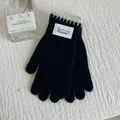Details schwarzer Strick-Thermohandschuhe mit kontrastierenden Wellenbündchen und Webetikett - Schwarz