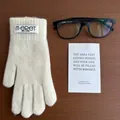 Detailed texture of warm cream knit gloves with touch screen tips and brand label - Off White