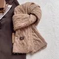 Detail of chunky cable knit wool scarf in soft camel with premium brand logo tag - Twist Pattern / Milk Tea Camel