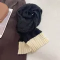 Detailed view of black and beige knit scarf with decorative label on soft texture - Black and Off-White