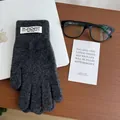 Detail van donkergrijze gebreide handschoenen met pluizige textuur en merklabel - donkergrijs