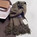 Detailed view of dark brown faux cashmere scarf with long tassels and premium brand label - Army Green