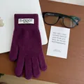 Detailed macro view of purple knitted touchscreen gloves with soft plush texture on wood - Dark Plum Purple