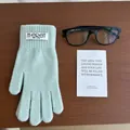 Detail van lichtgroene gebreide winterhandschoen met M-ERET-label op houten achtergrond - Aquagroen