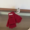 Detail of red wool knit convertible gloves with flip top and button on wooden background - Red