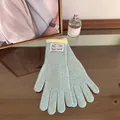 Detail of light blue knitted gloves showing soft rib texture and yellow contrast cuffs - Azure Blue