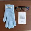 Close-up of soft light blue knit glove with branded label on a wooden desk background - Light Blue