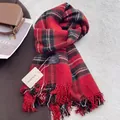 Close-up of red and black checkered scarf with soft fringes and branded woven label - New Year Red