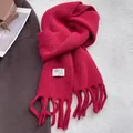 Dettaglio di sciarpa in maglia bordeaux con frange, posa piatta con accessori invernali - Rosso