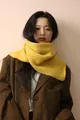 Close-up of bright yellow cable knit scarf paired with classic brown checkered wool blazer - Yellow