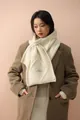 Detail of cream knit scarf featuring diamond pattern, brand tag, and button closure - Cream Rice