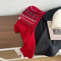 Detail of red Fair Isle knit balaclava showing thick ribbed wool texture and Nordic patterns - New Year Red