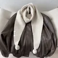 Detail of cream knit scarf with fluffy pom-poms and KN STUDIO label on a leather jacket - Off White