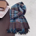 Close-up of classic checkered cashmere-feel scarf with elegant fringes and brand label - Vintage Blue