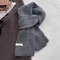 Dettaglio di sciarpa in pura lana grigia con trama a maglia spessa ed etichetta - Grigio