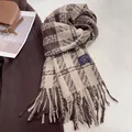 Macro shot of brown and beige plaid scarf texture with brand label and long tassels - 180cmx60cm / Camel