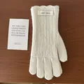 Nahaufnahme cremefarbener Wollhandschuhe mit vertikalen Streifen und Wellensaum-Details - Elfenbein