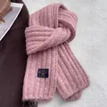 Detailed view of pink ribbed knit scarf texture featuring a navy brand logo woven label - Pink